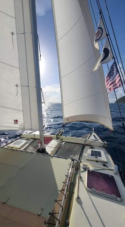 Mahiya under full sail with American flag flying on a sunny day