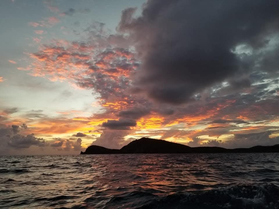 Fiery orange and purple sunset silhouetting a Virgin Islands peak