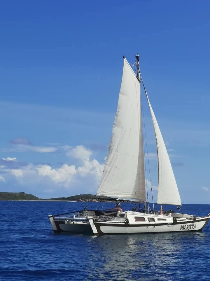 Mahiya catamaran under full sail on open water with Virgin Islands in the background