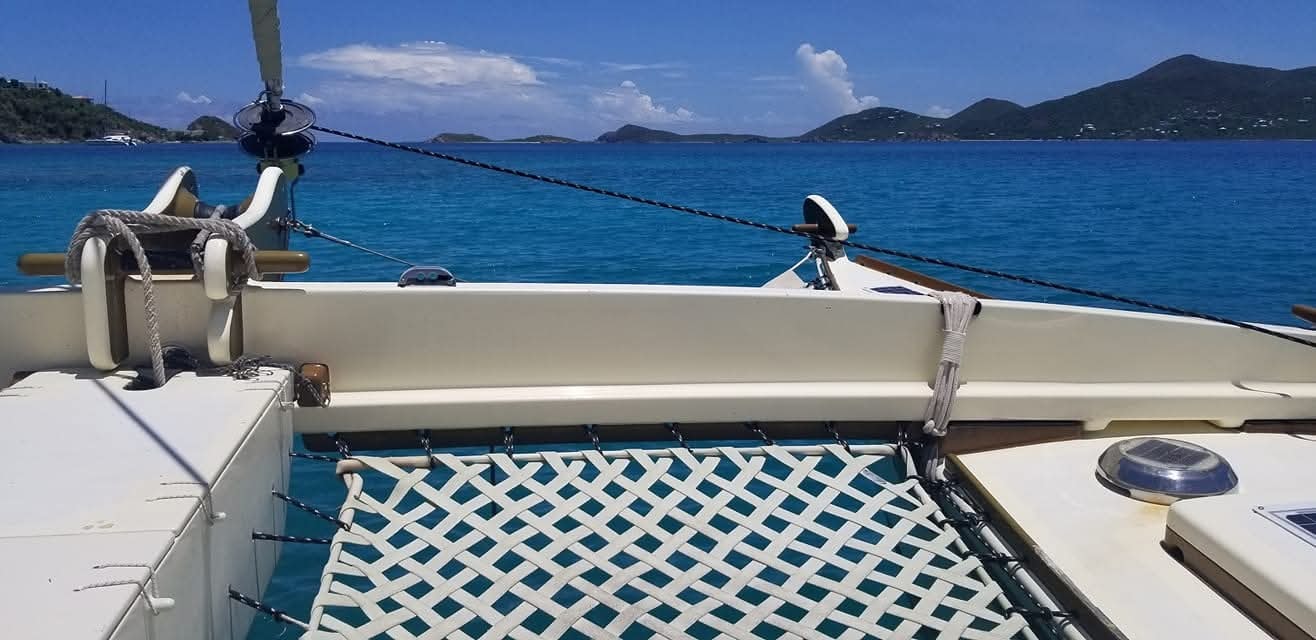 View from the Mahiya bow trampoline net looking forward at turquoise water and VI islands