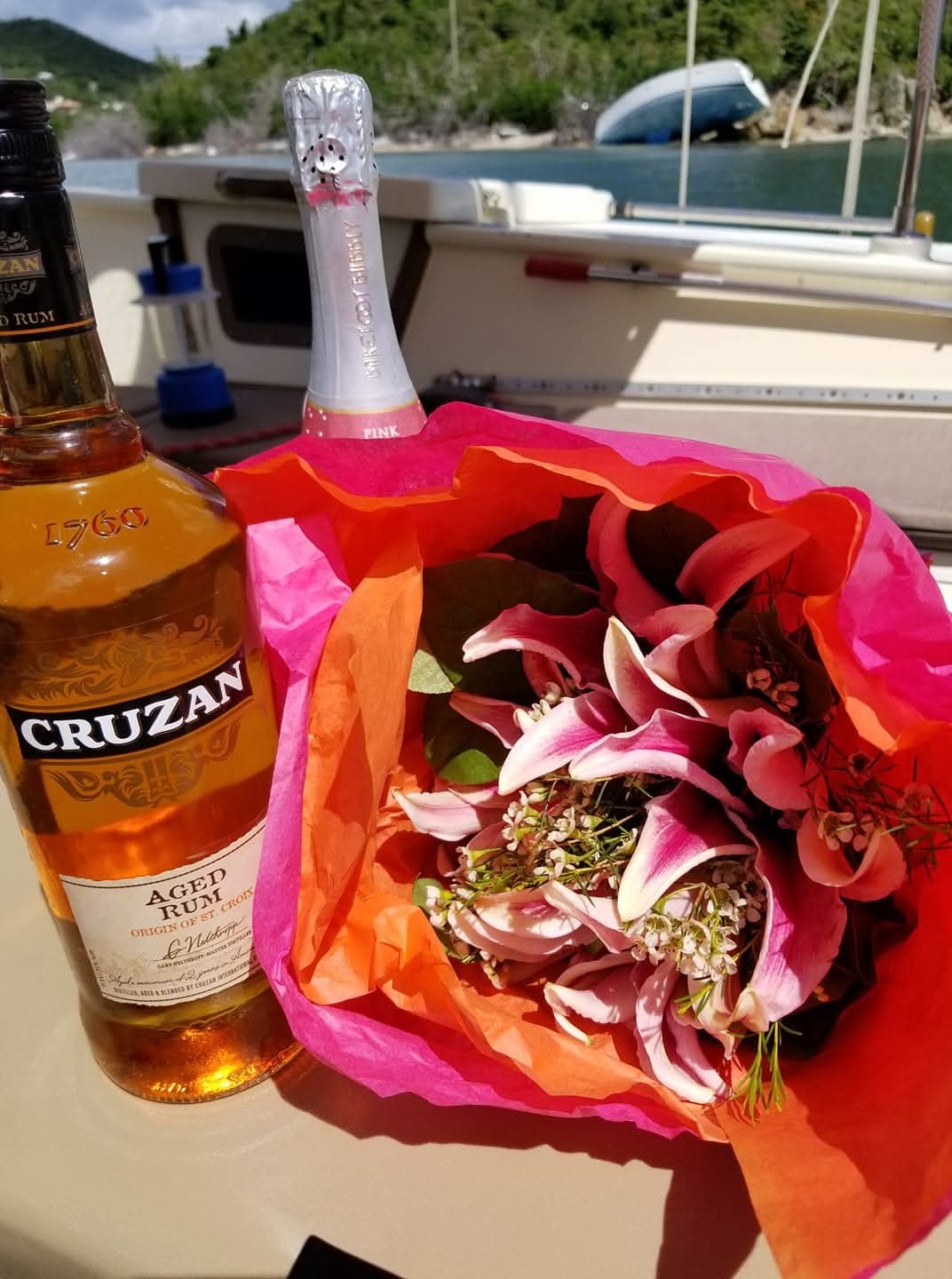 Cruzan rum, pink bubbly, and tropical flowers on the Mahiya deck — perfect for a celebration