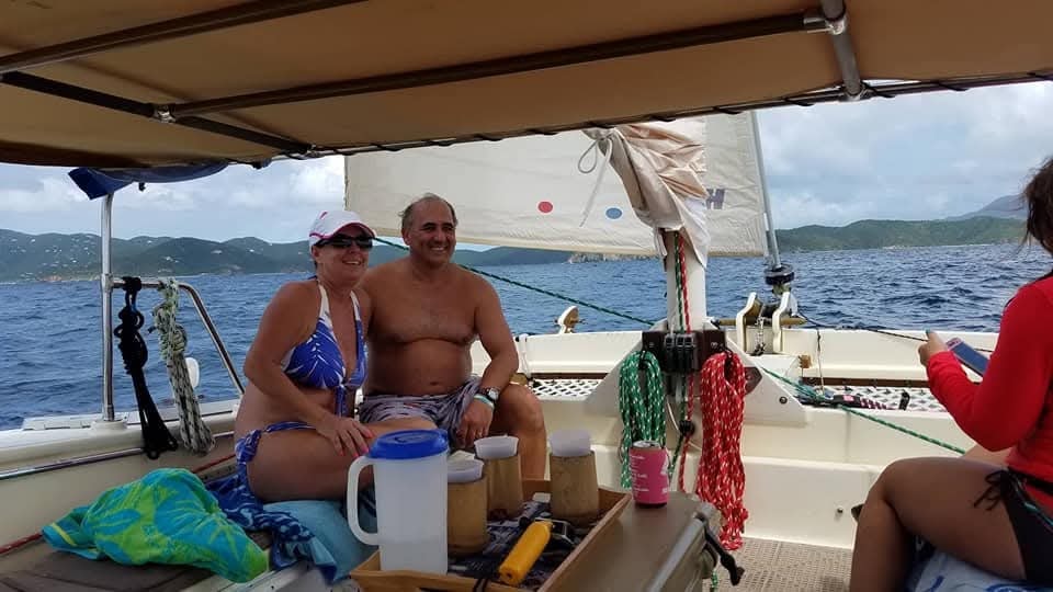 Happy couple smiling under the bimini with drinks on a Virgin Magic charter
