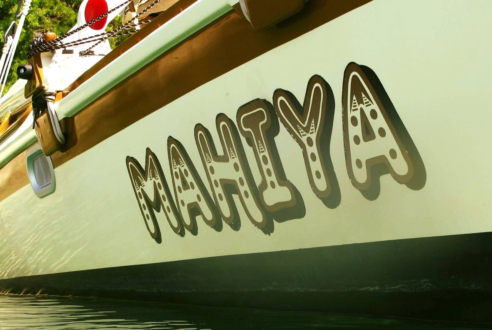 Close-up of the Mahiya name painted in decorative lettering on the hull of the catamaran