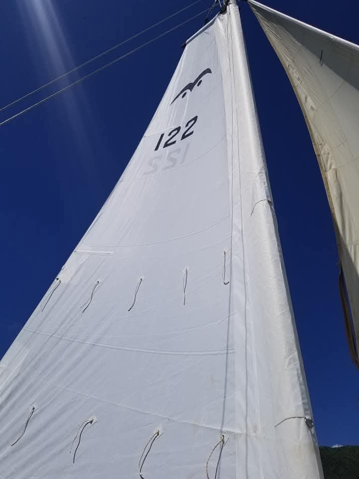 Mahiya's sail number 122 against a deep blue Caribbean sky